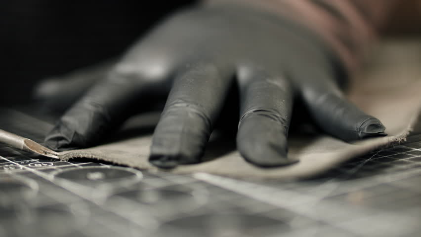 Artisan cutting leather piece with precision knife