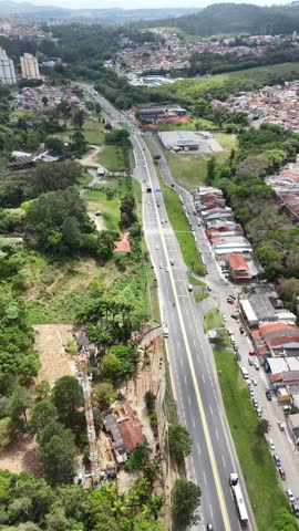 Panoramic vertical aerial drone shot of Mogi das Cruzes city with the main road connecting the Alto Tietê region to the São Paulo coast.