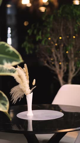 Placing a vase with red roses on a café table