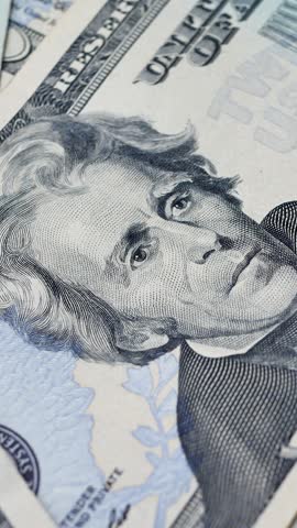 Detailed shot of overlapping 20 dollar bills highlighting Andrew Jackson portrait. National currency used for trade, business transactions, and financial exchanges