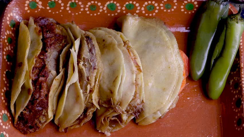 Hands preparing delicious traditional mexican steamed tacos with cabbage and chilis on a clay plate