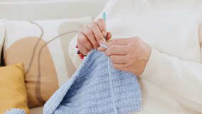 Close up granddaughter knits a cozy blue blanket during the holidays - Powered by Shutterstock - Get 15% off with code: PIKWIZARD15