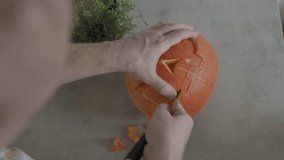Man hands carving creepy face orange Halloween pumpkin table Concentrating on their Creativity Halloween October 31. Jack O Lantern pumpkin at home family kitchen table. Preparing for family holiday. - Powered by Shutterstock - Get 15% off with code: PIKWIZARD15
