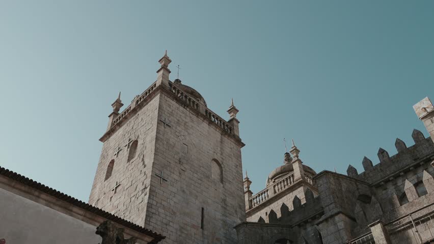 Low angle view of medieval stone tower and ornate architecture inside historic palace in Porto Portugal