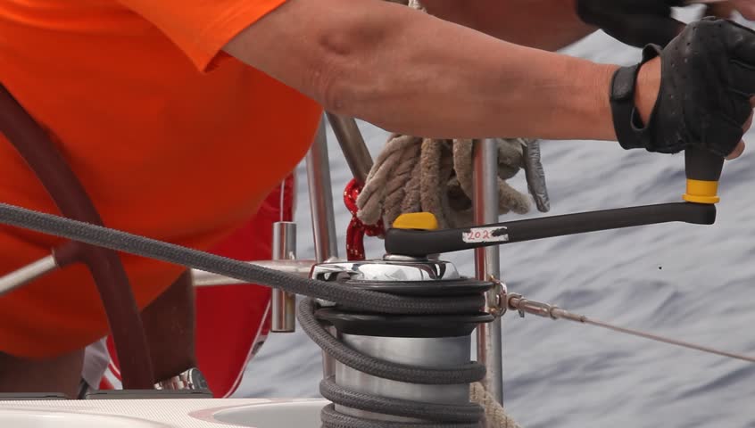 Man pulling ropes (HD), winding sheets around winches, shot in full HD