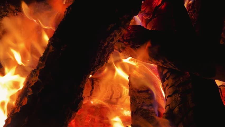 Astrakhan Region,Russia: A campfire on a sandy beach on the banks of the Volga River. A burning campfire on the banks of the Volga River in complete darkness. Sparks from the campfire, flames at night