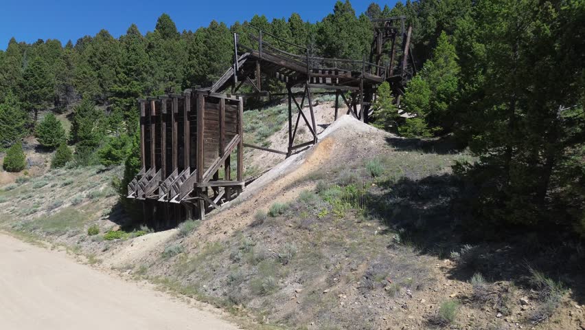 Ghost town of Comet Montana. Closeup flyover shot of the ruins of the ore loading chute and tramway above it.