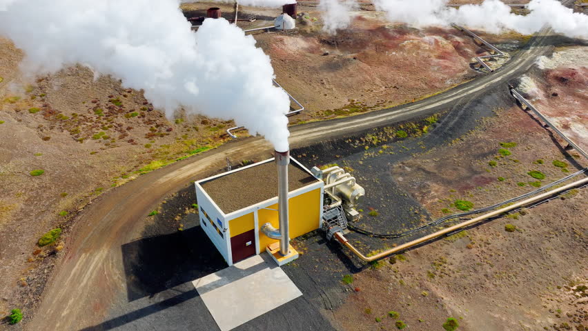 The pipe emits white smoke under enormous pressure, Geothermal Energy Power Plant Working In Iceland, Located in a Picturesque Volcanic Landscape At Summer Season