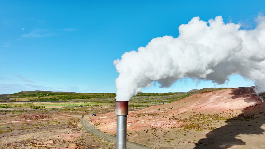 The pipe emits white smoke under enormous pressure, Geothermal Energy Power Plant Working In Iceland, Located in a Picturesque Volcanic Landscape At Summer Season
