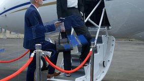 Business duo by jet steps holding phone, gesturing as charts expanding for flight planning. Luxury, collaboration, innovation, technology, corporate, executive, business - Powered by Shutterstock - Get 15% off with code: PIKWIZARD15