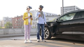 A couple wearing VR headsets while their electric vehicle charges at a charging station. - Powered by Shutterstock - Get 15% off with code: PIKWIZARD15