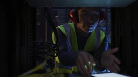 Kneeling technician adjusting cables and using tablet in data center activating binary diagnostics. Technology, cybersecurity, innovation, digital, connectivity, industrial, futuristic - Powered by Shutterstock - Get 15% off with code: PIKWIZARD15