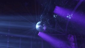 rotating disco ball shinning purple and blue light beams in dimly lit event space - Powered by Shutterstock - Get 15% off with code: PIKWIZARD15