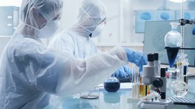 Medical Laboratory Scientists in White Coats Work at Lab Benches Using Pipettes, Microscopes, Test Tubes. Team Examines Biological Samples, Records Data, Operates Scientific Equipment and Research - Powered by Shutterstock - Get 15% off with code: PIKWIZARD15