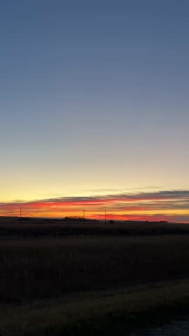 Beautiful glowing sunset over the prairie horizon with colorful sky and soft evening light.