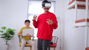 Young asian man experiencing virtual reality technology while friend give instructions on laptop - Powered by Shutterstock - Get 15% off with code: PIKWIZARD15