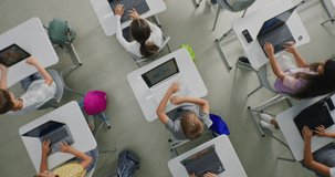 Children Sit at Desks Using Laptops, Surrounded by Luminous Digital Lines Symbolizing Virtual Connection and AI Collaboration. Technology Integration, and Future Focused Learning. Rotating Top View. - Powered by Shutterstock - Get 15% off with code: PIKWIZARD15