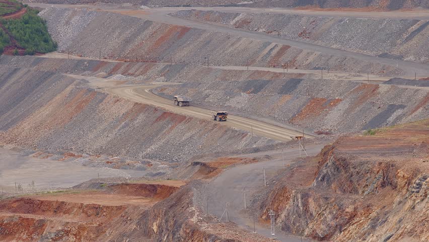 Aerial view Big yellow mining trucks lifts along road. Open pit mine of gold, copper ore, dumpers, quarrying extractive industry stripping work.