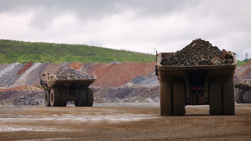 Back view Big dump truck with Ore work in open gold pit mine. Process mining industry workplace.