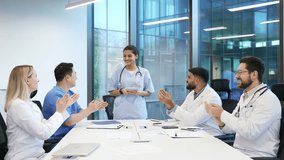 Female doctor giving a successful presentation to a group of medical professionals on conference in meeting room. Speaker reporting on great results. Team of physicians celebrating success applauding - Powered by Shutterstock - Get 15% off with code: PIKWIZARD15