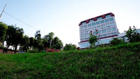 An energetic young man enjoys active recreation and parkour in the heart of Sumy, Ukraine. He performs a somersault on a grassy lawn next to blooming roses, symbolizing freedom, youth, and vitality. - Powered by Shutterstock - Get 15% off with code: PIKWIZARD15