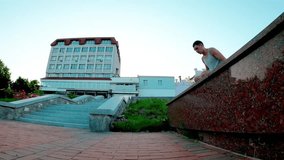 A young man practices a handstand near the Sadko Fountain in Sumy, Ukraine. He performs a controlled jump from the ledge to a handstand on the ground, demonstrating balance, strength, and precision - Powered by Shutterstock - Get 15% off with code: PIKWIZARD15