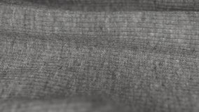 Factory-made grey knitwear. Slow motion. Moving grey texture of ribbed knitted fabric . The movement of a wavy knitted fabric. - Powered by Shutterstock - Get 15% off with code: PIKWIZARD15