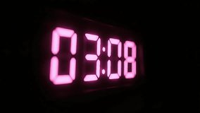 A glowing pink digital LED clock illuminates a dark space, showcasing time changes in a modern and minimalistic style. The vibrant, luminous display creates a futuristic and atmospheric visual - Powered by Shutterstock - Get 15% off with code: PIKWIZARD15