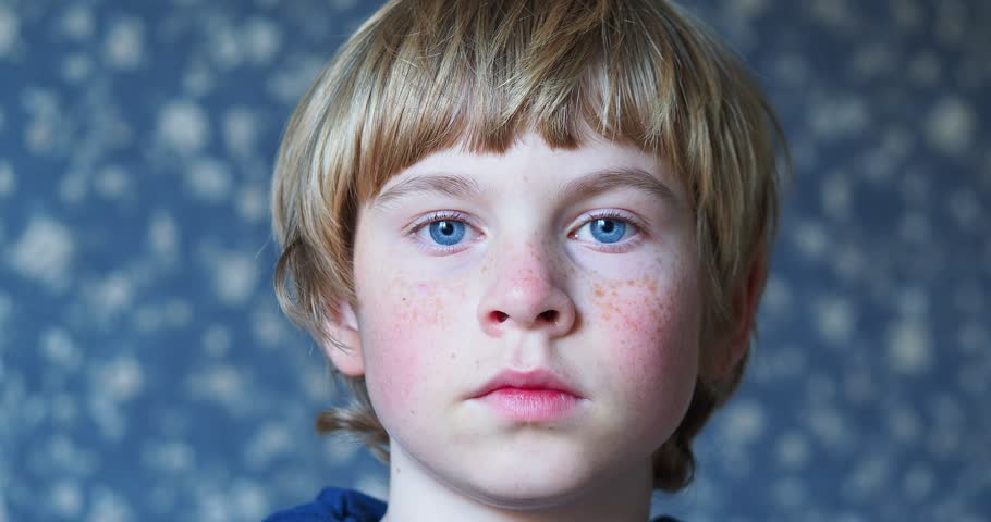 Close-up portrait of a boy with a smile and blue eyes