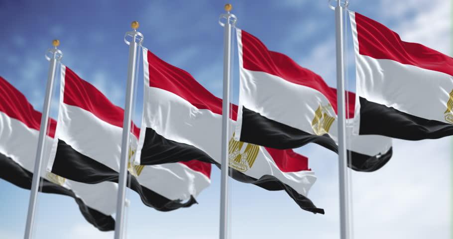 National flags of Egypt waving on a clear day. Horizontal red, white and black bands. Egyptian eagle emblem centered in white band. Seamless 3d render animation. Slow motion loop. Selective focus