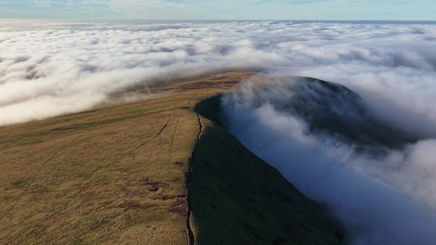 Drone flying over a mountain ridge above a temperature inversion in Brecon Beacons, Wales