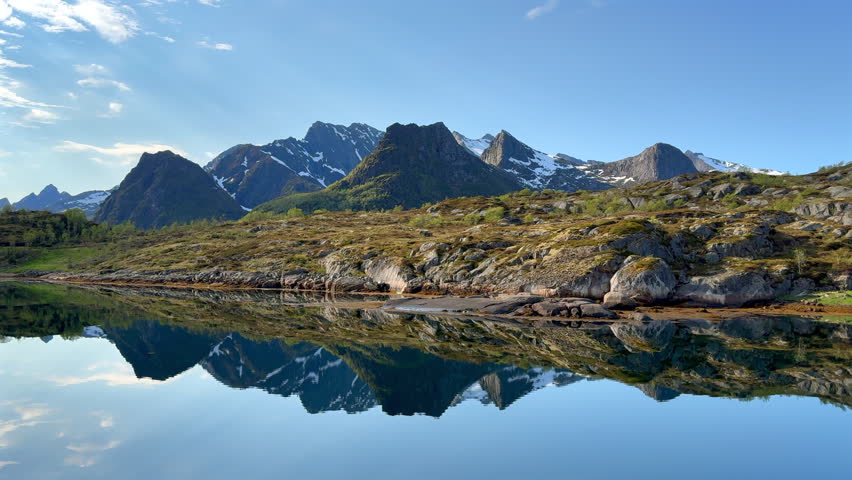 Stunning Norwegian landscape with mountains reflecting perfectly in the serene water of a fjord