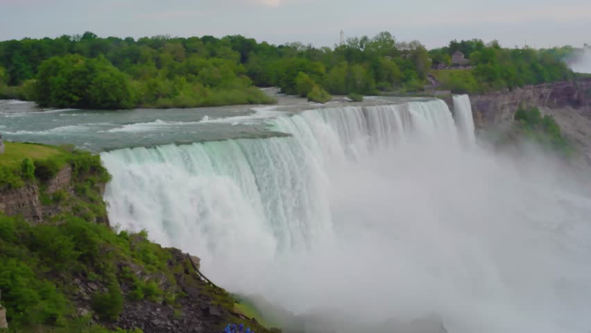 A video of the American - Canadian waterfalls Niagara Falls on a cloudy day. beautiful view of the Niagara Falls in summer with mist in the air.