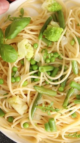 Spaghetti vegetables green peas, broccoli, string beans, kohlrabi vegetarian pasta tasty snack fresh delicious gourmet food background on the table rustic top view copy space vegan food