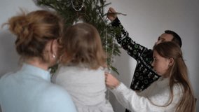 family with toddler and teenager decorates pine wreath, Christmas tree for home decor - Powered by Shutterstock - Get 15% off with code: PIKWIZARD15