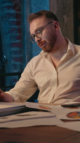 Tired sleepy Caucasian business man yawning stretching in night office computer using fatigued overworked businessman male guy company CEO yawn stretch arms in dark evening workplace insomnia trouble