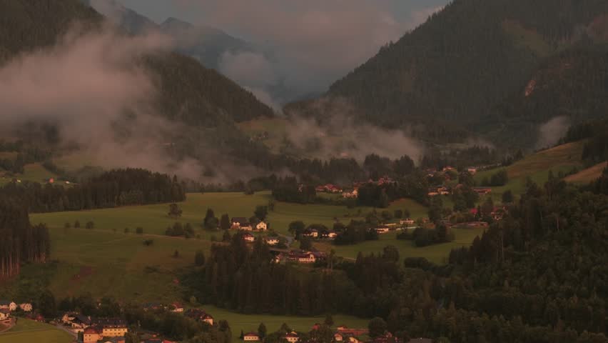 Scenic landscape with rolling hills and misty mountains, camera pans across the serene valley