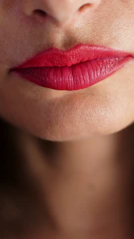 Sweet temptation. Cropped closeup of a red lipped female biting on a chocolate, Lips of beautiful brunette woman eating chocolate with hazelnuts