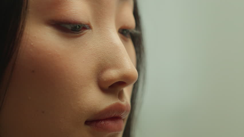 Female face skincare young Asian woman holding white flower sniffing aromatic smell indoor in studio Korean Chinese Japanese girl model bloom floral perfume allergy treatment collagen beauty procedure
