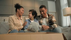 African American positive family at home happy boy son kid child take Teddy Bear toy from order delivery parcel gift open box surprise joyful reaction lovely parents caring custody adoption moving day - Powered by Shutterstock - Get 15% off with code: PIKWIZARD15