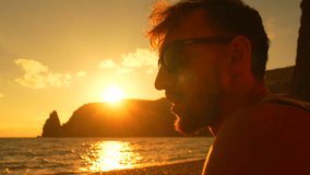 Man sunset beach. Profile of a man with sunglasses relaxing on a beach at sunset. Peaceful vacation moment - Powered by Shutterstock - Get 15% off with code: PIKWIZARD15