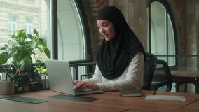 Happy smiling positive Muslim business woman in hijab typing laptop Islamic female girl student employer arabian businesswoman entrepreneur in office working online chatting with internet computer - Powered by Shutterstock - Get 15% off with code: PIKWIZARD15