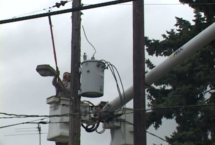 Person from power company turning off power from power line in series of clips.