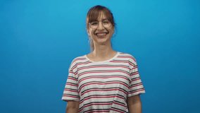 Woman reaching forward with outstretched arms and visible forearms wearing striped shirt in blue studio smiling broadly and open palms; joy welcome connection. - Powered by Shutterstock - Get 15% off with code: PIKWIZARD15