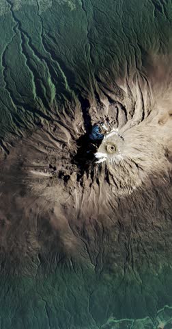 Aerial shot of Kilimanjaro volcano surrounded by jungles. Camera is moving forward. Vertical video. Animation based on image by NASA