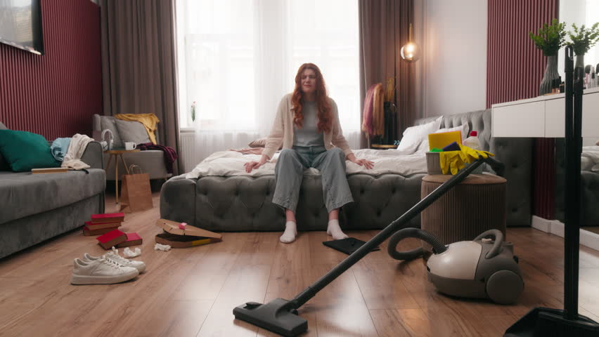 Caucasian woman yawn in messy dirty bedroom in morning yawning after party mess disorder tired girl overwhelmed homeowner at home cleaning stress female housewife lazy clutter chaos routine chore