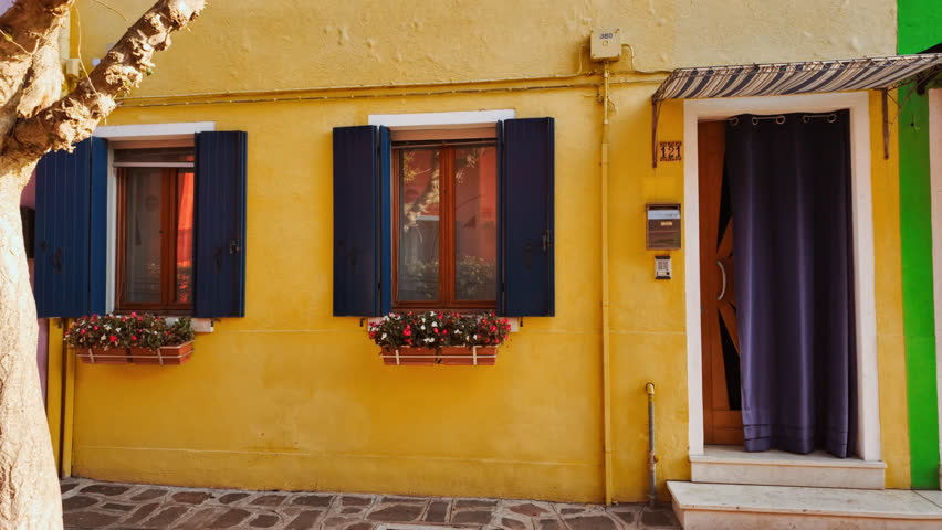 Colorful buildings on the island of Burano, Venice, Italy, with bright facades, canals and moored boats
