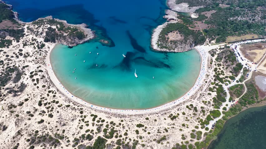 Establishing aerial view of the popular Voidokilia beach in Messinia, Peloponnese, Greece, with sand dunes and turquoise sea