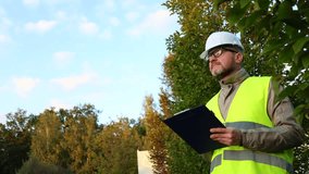 Inspector engineer using a tablet to take notes on a construction site. Male forestry studying the condition of trees in the forest. Work . Eco control. Ecologist conducting environmental monitoring.	 - Powered by Shutterstock - Get 15% off with code: PIKWIZARD15