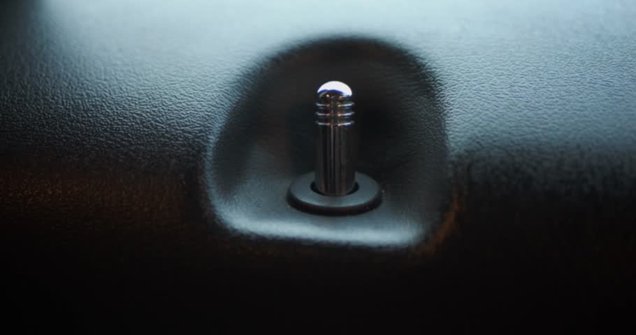 Extreme close-up of a car door lock pin, focus on automotive security, detail, and modern vehicle interior.